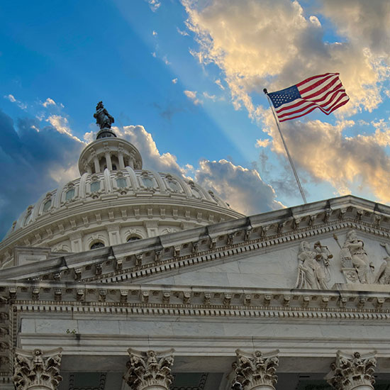 US Capitol Building rotunda looking skyward toward partly cloudy skies